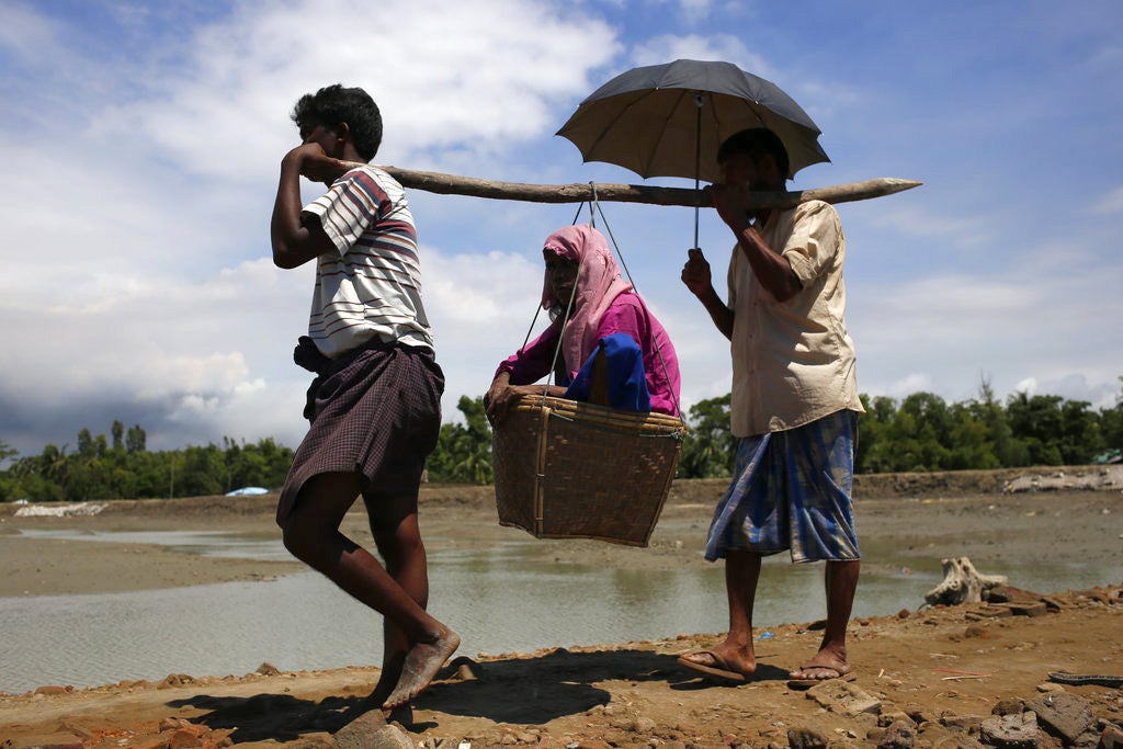 Rohingya people refugees carry an older woman on the way to camp at Shahpori Island, in Teknaf, Bangladesh on September 13, 2017. 