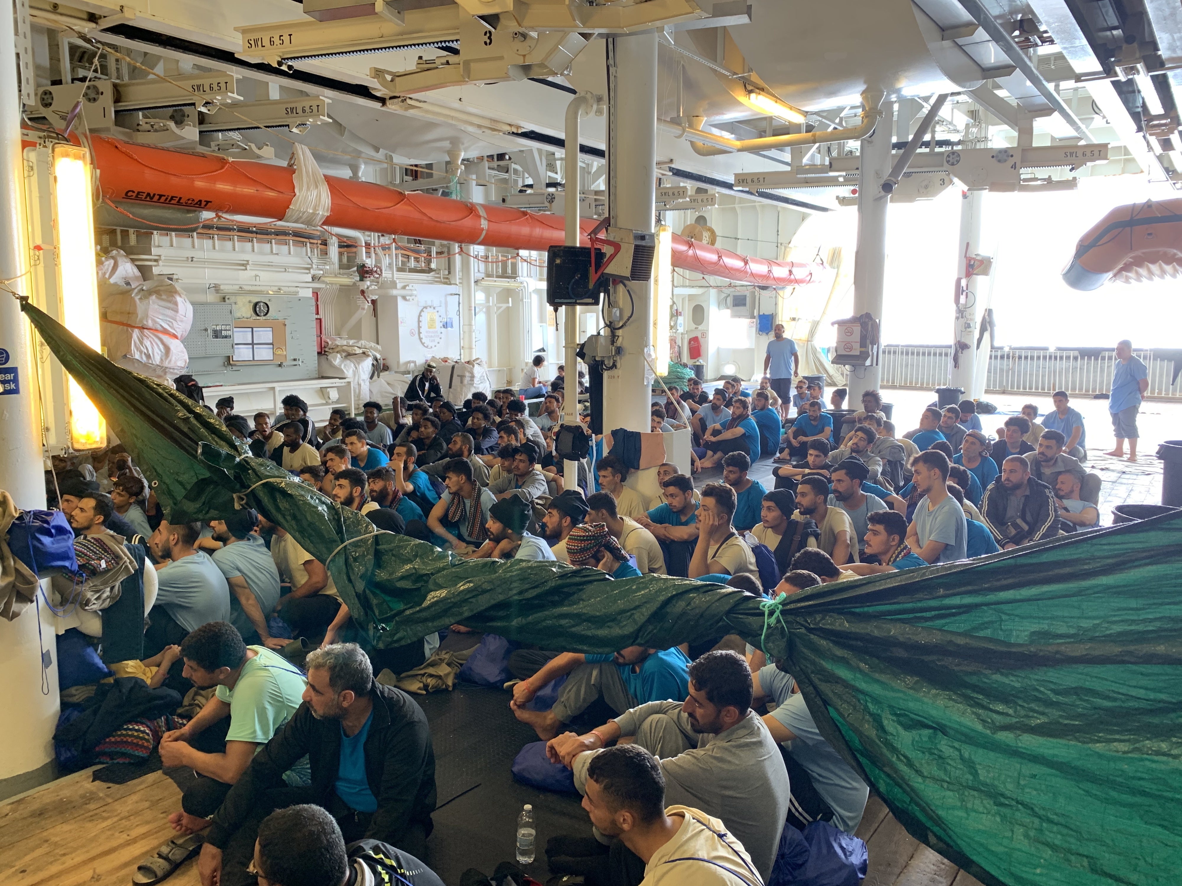 Survivors on the men’s “shelter deck” on the Geo Barents receiving information from the MSF crew, September 20, 2024. 