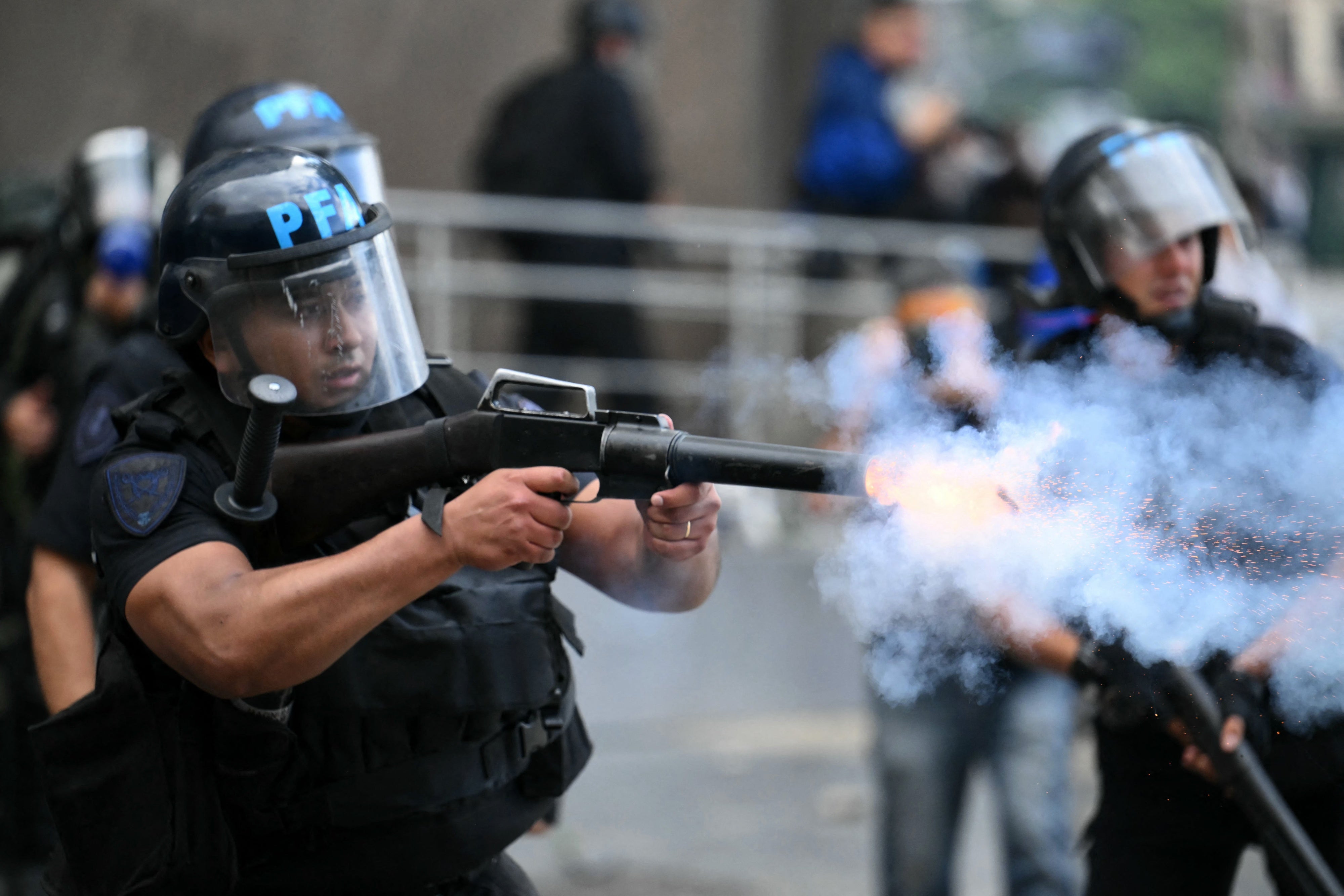 A riot police officer shoots a tear gas canister at protesters during a demonstration of pensioners calling for improvements to their pensions and access to free medicines, among other demands, in Buenos Aires on March 12, 2025.