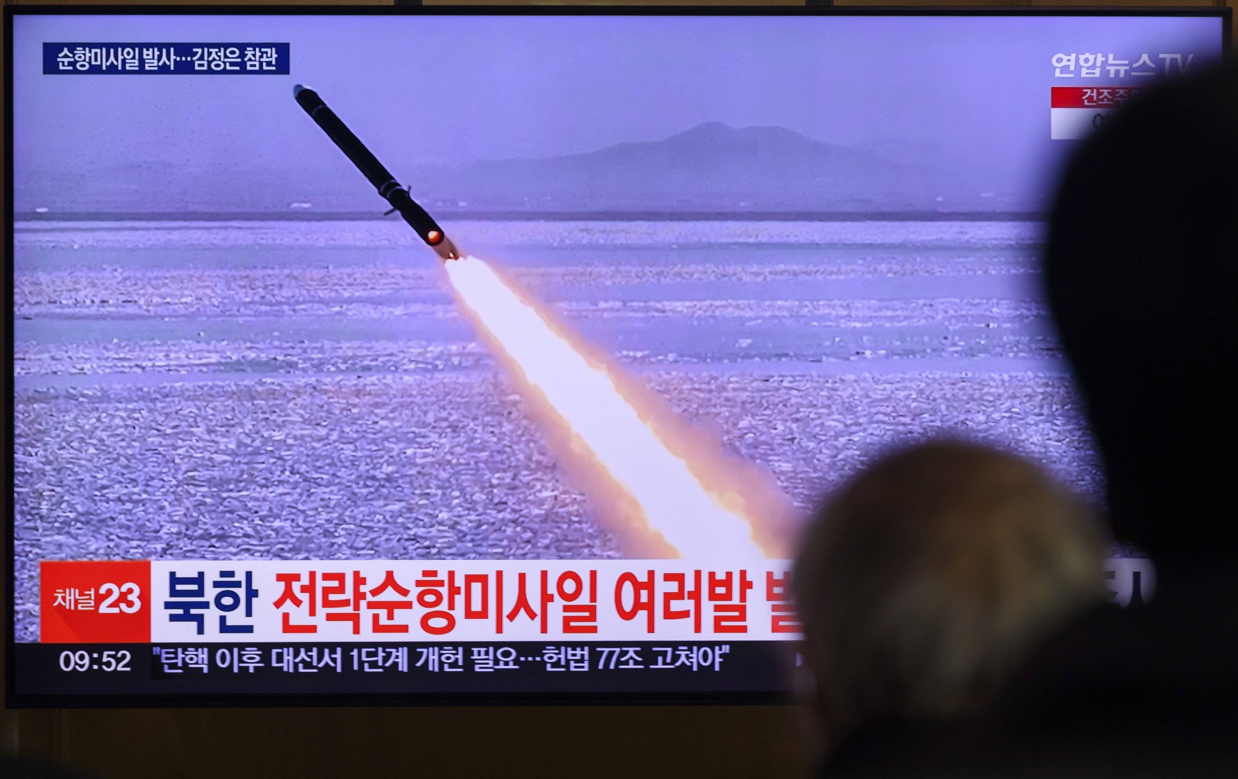 A TV shows a missile launch.