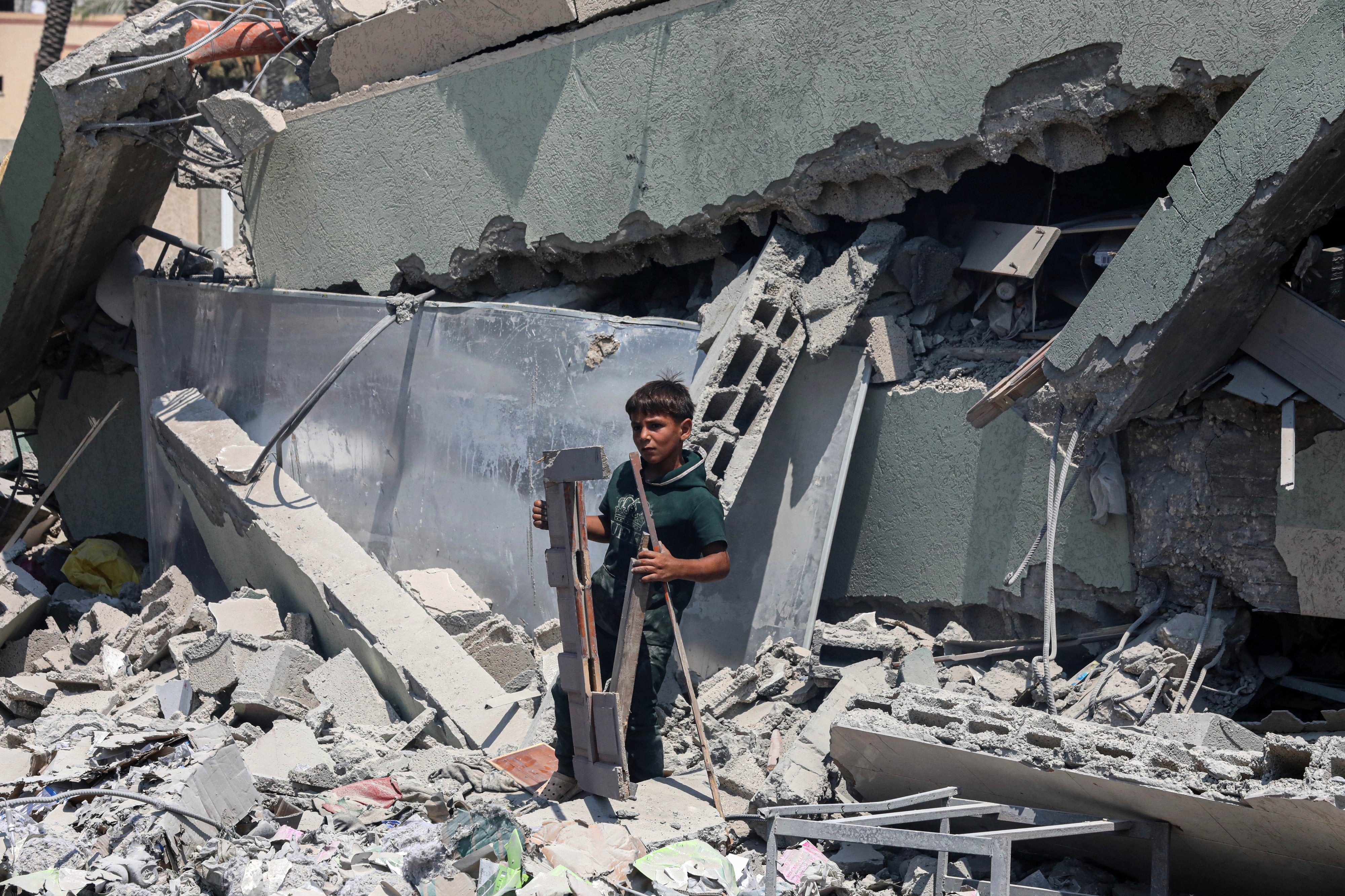 A boy stands on the rubble of Khadija School in Deir al-Balah, central Gaza, which an Israeli airstrike hit on July 27, 2024, killing at least 15 displaced Palestinians.