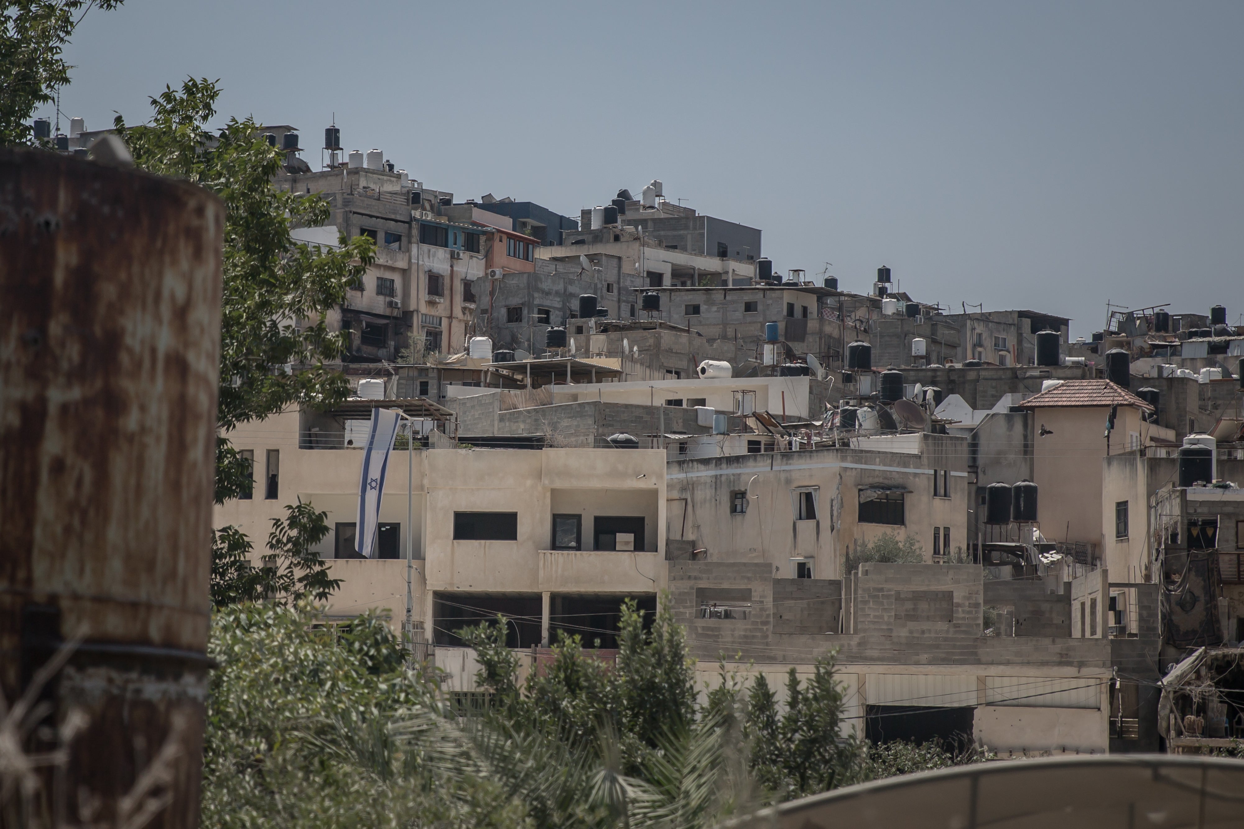 An Israeli flag hangs from a Palestinian building in Nur Shams refugee camp