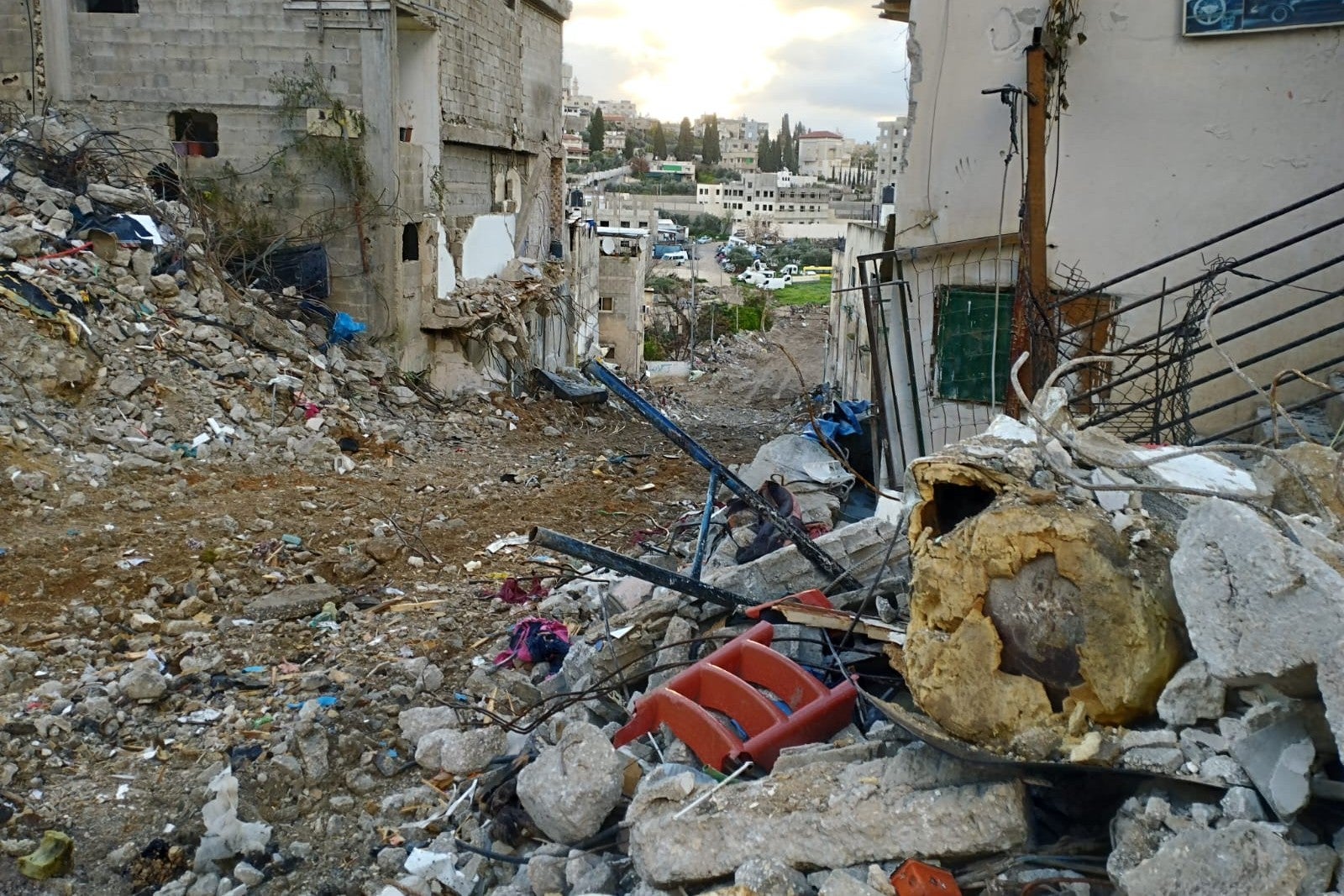 Palestinian homes and debris from destroyed houses are seen lining a street 