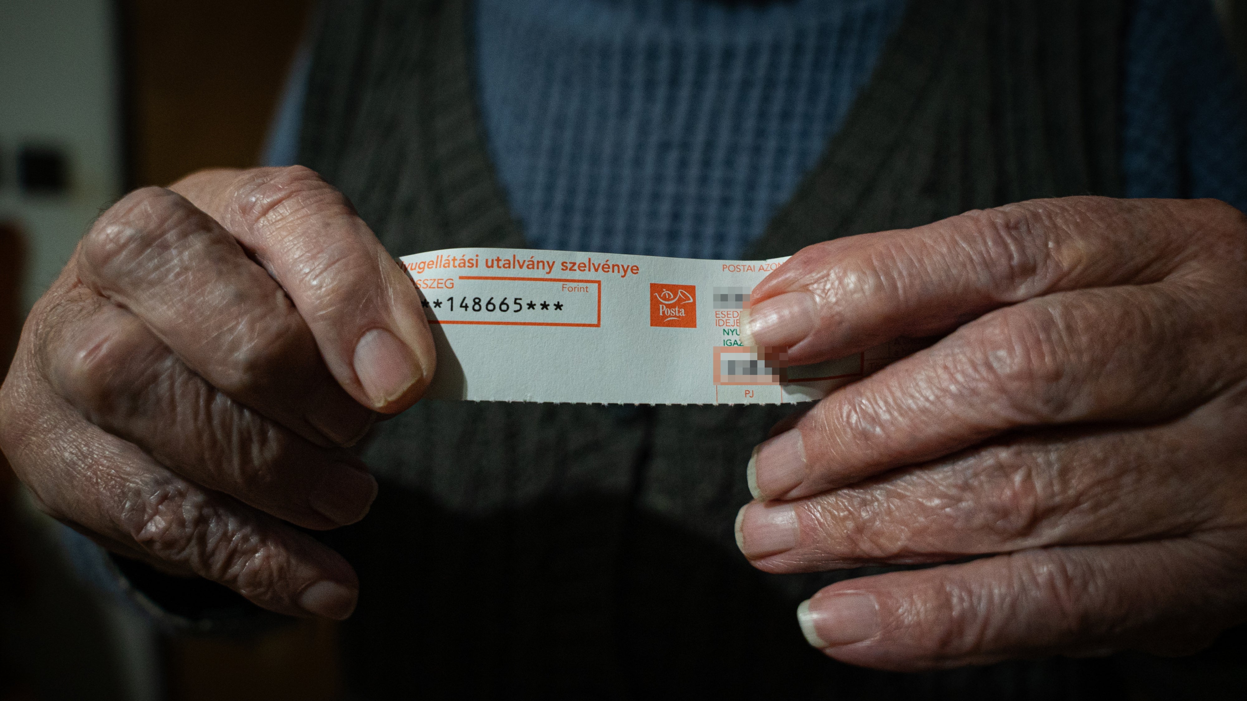 Béla, a retired agricultural worker, holds a slip of paper that confirms his monthly pension of 148,665 HUF (€376). Szabolcs-Szatmár-Bereg county, Hungary, November 2025.