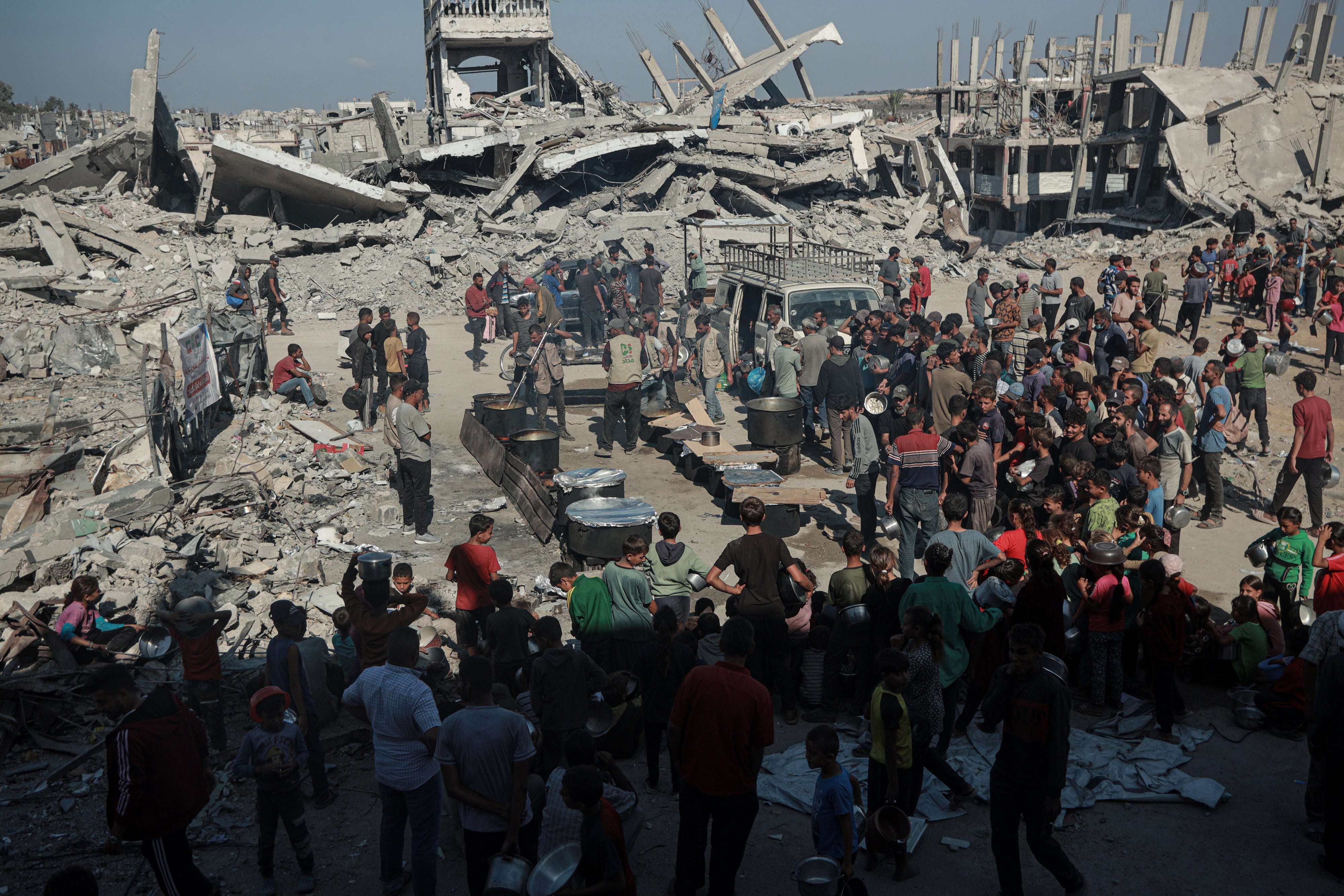 Palestinos acuden en grandes números a la zona donde una organización benéfica distribuye comida caliente mientras persiste la crisis alimentaria en Beit Lahia, Gaza, el 28 de octubre de 2025. 