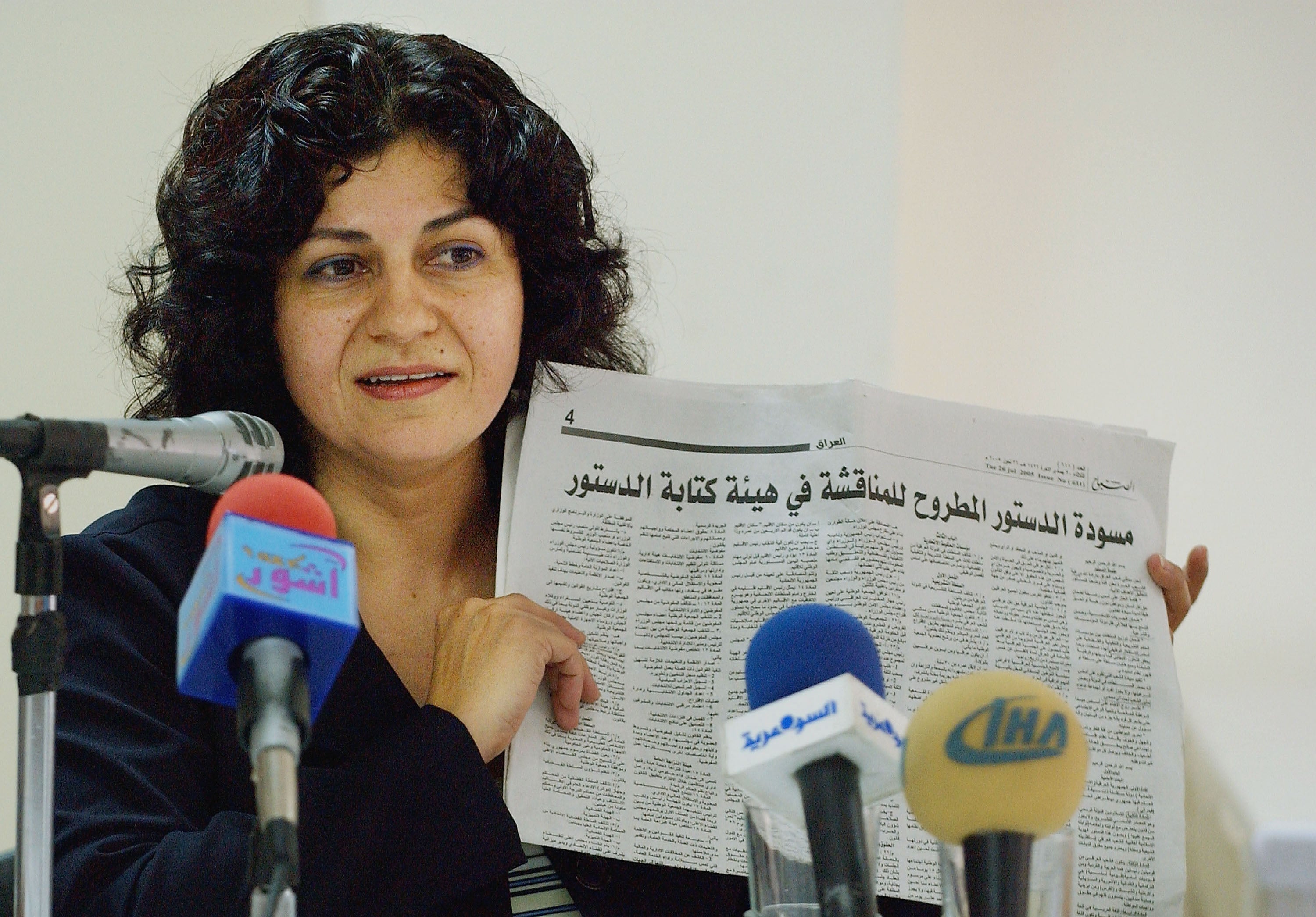 Yanar Mohammed, founder of the Women's Freedom Organization in Iraq, speaks to reporters while holding a newspaper copy of Iraq's new constitution,  Baghdad, July 28, 2005. 