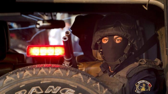 A masked Egyptian policeman watches Tahrir Square in Cairo, Egypt.