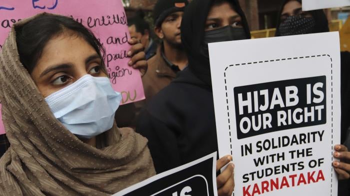 Women in masks holding up protest signs