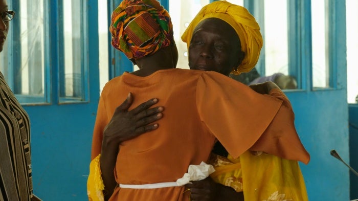 A witness embraces counsel at the Gambian Truth, Reconciliation and Reparations Commission, which called for the prosecution of former President Jammeh, the “Junglers” and others for alleged crimes, in Eassau, Gambia. 