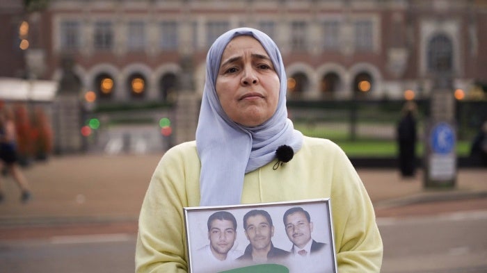Amneh Khoulani holding a photo of her brothers at the International Court of Justice in The Hague, Netherlands, on October 10, 2023.