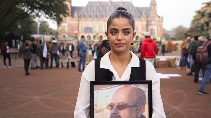 Wafa Ali Mustafa holding a photo of her father Ali Mustafa who disappeared in Syria in 2013 at the International Court of Justice in The Hague, Netherlands, on October 10, 2023.