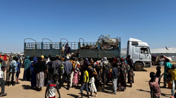 People get out of a truck that brought them from the border with Sudan to the transit center in Renk, South Sudan; just a few suitcases and bed railings can be seen.