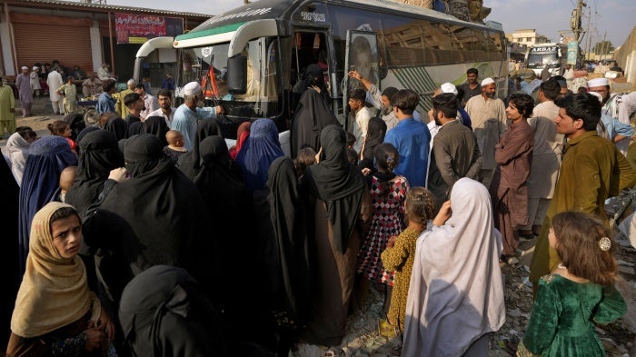 People board a bus to depart for Afghanistan, in Karachi, Pakistan, October 31, 2023.
