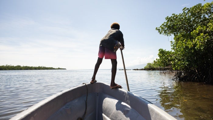 Boy on a boat in the mangroves near the village of Walande.