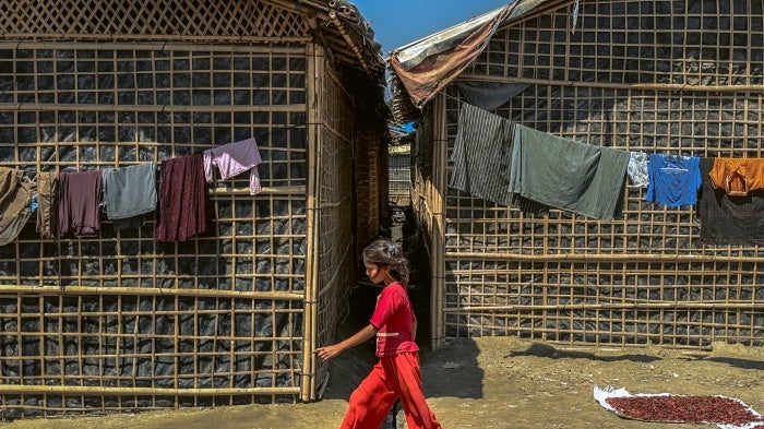 A Rohingya girl walks past shelters in a refugee camp in Cox's Bazar, Bangladesh, March 9, 2025.