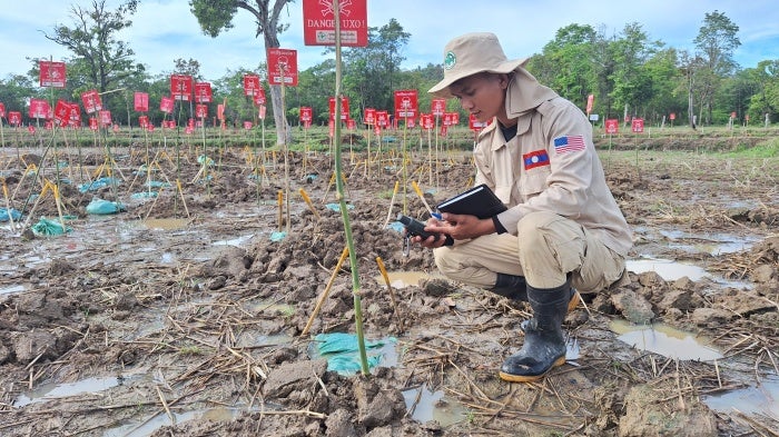 In Paksong district of Saravane province, Laos, a clearance technician from Norwegian People’s Aid uses a GPS device to record the coordinates of cluster munition remnants in a rice field where 178 BLU-26 submunitions were found. 