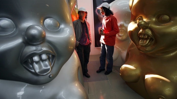 Chinese artists the Gao Brothers, Zhen and Qiang, with some of their "Miss Mao" pieces that feature life-sized, Pinocchio-nosed sculptures of Mao Zedong in their studio in Beijing, October 16, 2007.