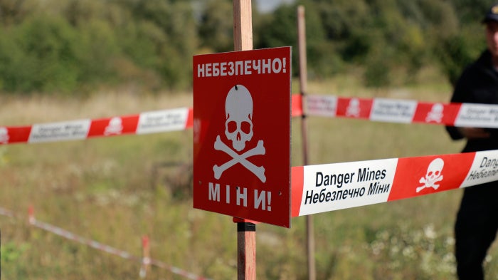 Sign reading "danger mines" in English and Ukrainian.
