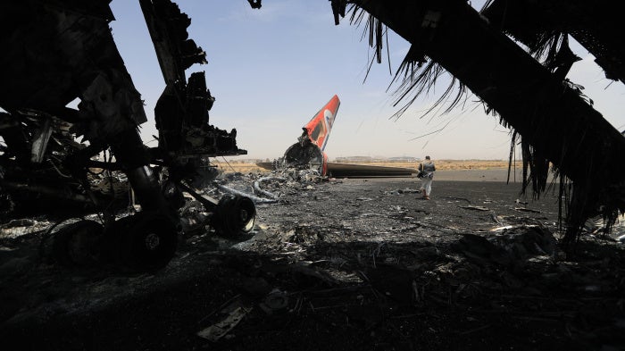 A Houthi rebel next to a destroyed plane at the Sanaa International Airport on May 7, 2025, a day after Israel's military warplanes struck Yemen's rebel-held capital Sanaa. 