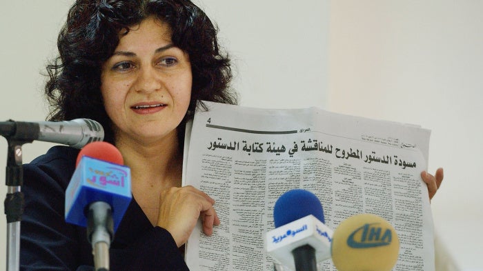 Yanar Mohammed, founder of the Women's Freedom Organization in Iraq, speaks to reporters while holding a newspaper copy of Iraq's new constitution,  Baghdad, July 28, 2005. 