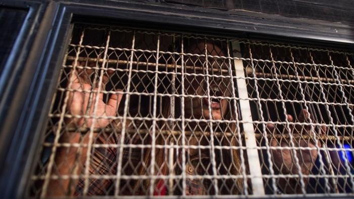 A demonstrator shouts from inside a prison van after being detained by Myanmar police during an anti-war protest in Yangon, May 12, 2018. 