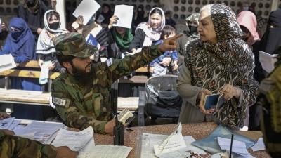 A man in military uniform points in the face of a woman 