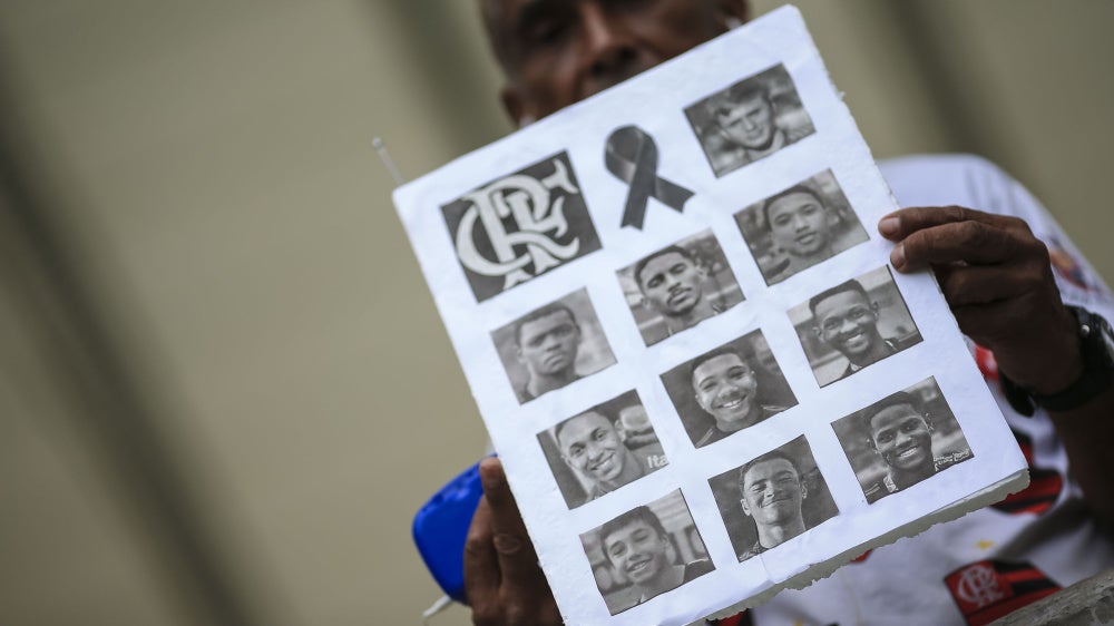 A fan shows photos of athletes of died