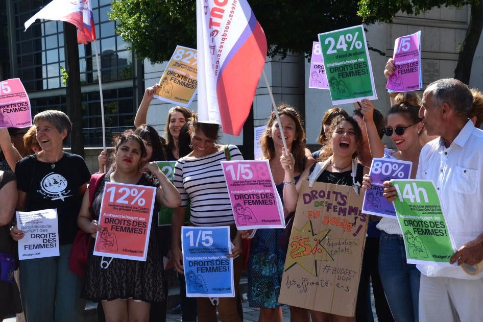 People holding signs against sexual harassment at work protest cuts to France's Ministry of Women's Rights budget, July 21, 2017.