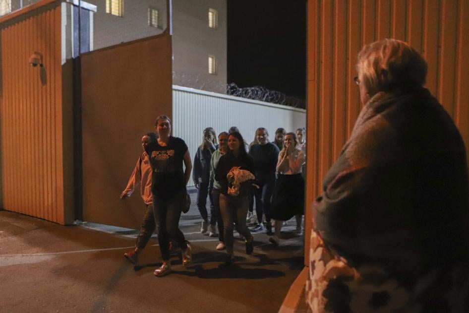 Women walk through a gate on Friday, Aug. 14, 2020, after being released from a detention center where they were detained following protests of the disputed presidential election in Minsk, Belarus. 