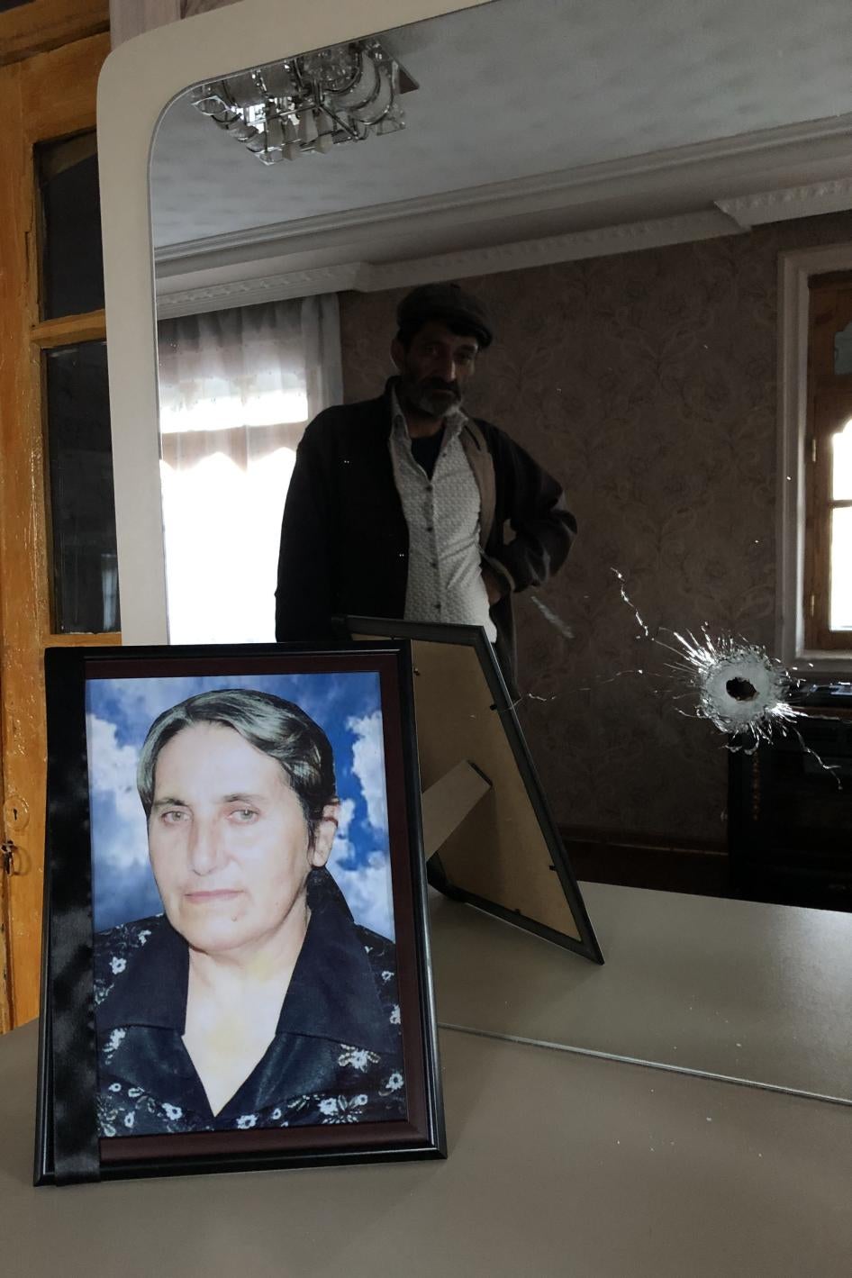 Yashar Abbasov keeps a photograph of his wife, Raziya Abbasova, on a dresser with a mirror which was damaged in the attack that killed her. 