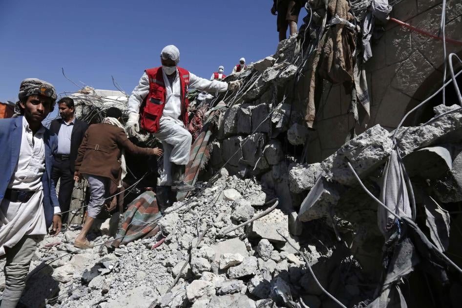 Rescue members remove rubble&nbsp;covering victims of aerial attacks carried out by the Saudi and UAE-led coalition.