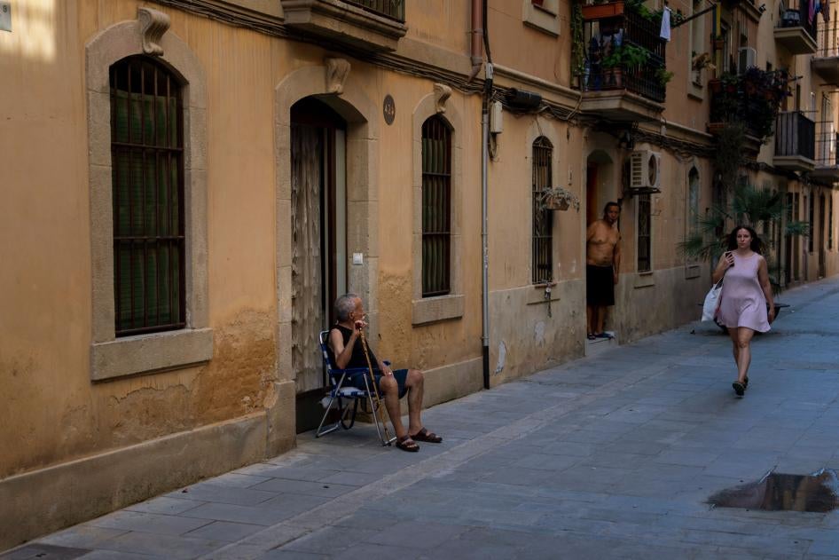 An older man sits outside his house during a heat wave in Barcelona, Spain