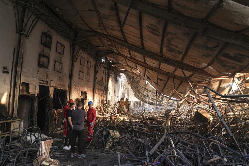 Des membres de l'équipe de secours travaillent dans une salle incendiée après qu'un incendie mortel ait ravagé la salle lors d'une célébration de mariage, le 27 septembre 2023.