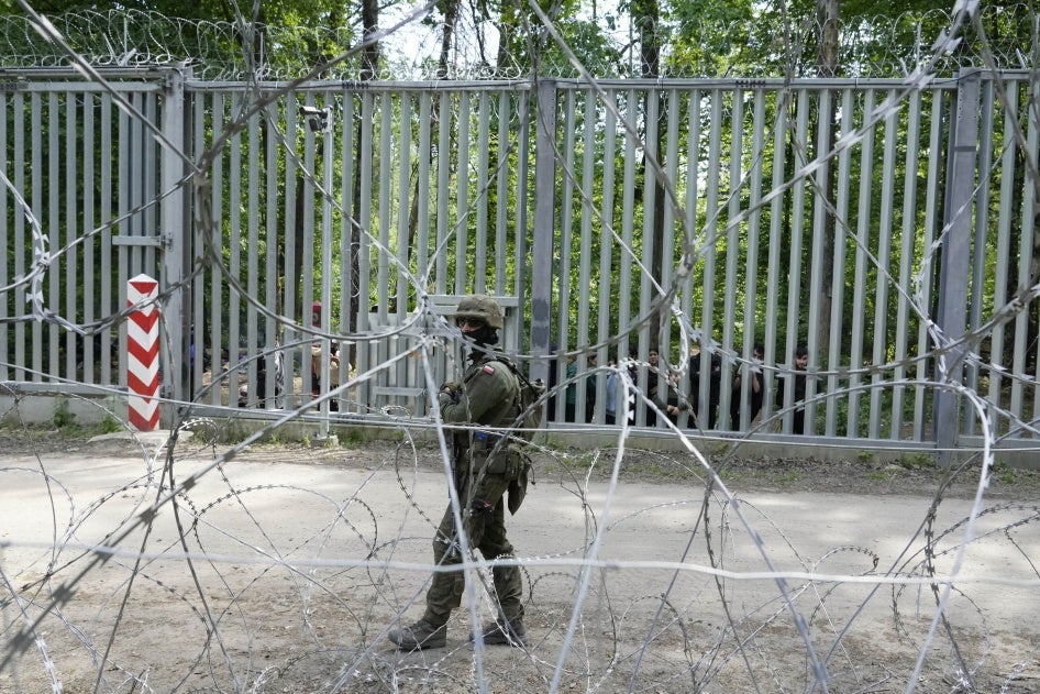 A Polish soldier patrols the metal barrier border with Belarus, in Bialowieza Forest, with migrants stranded on the Belarusian side, May 29, 2024.