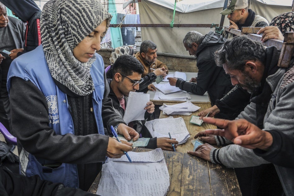Palestinians receive humanitarian aid from the United Nations Relief 