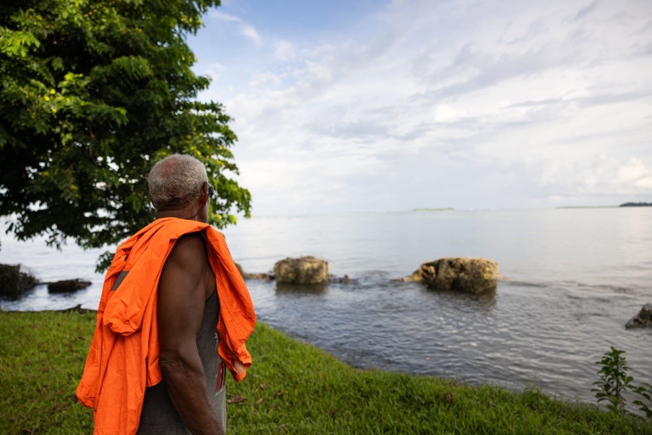 Community leader looks out to the seawall that has recently fallen apart and no longer protects the village of Walande, Malaita Province, Solomon Islands. 