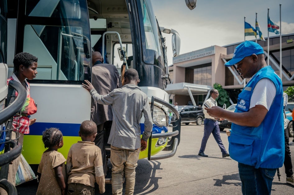 Displaced people board a bus after undergoing checks at the border between the Democratic Republic of Congo and Rwanda