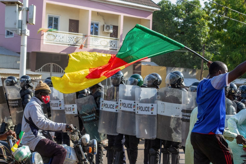 Un manifestant brandit un drapeau du Cameroun devant des policiers qui se rassemblent à Garoua, le 26 octobre 2025.