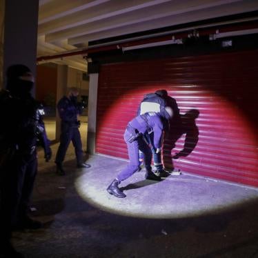 Police search a man at night