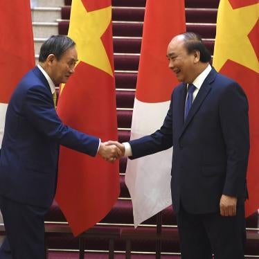 Japan's Prime Minister Yoshihide Suga, left, shakes hands with Vietnam's Prime Minister Nguyen Xuan Phuc after the exchange of documents at the Government Office in Hanoi on Monday, October 19, 2020. 