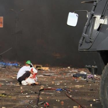 A volunteer tends to an injured demonstrator in front of a police armored personnel carrier (APC) in Rab’a Square in Cairo, Egypt on August 14, 2013