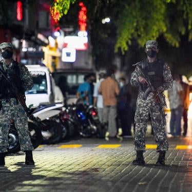 Armed police officers stand in a road