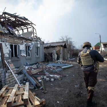 A member of the Ukrainian armed forces walks past the wreckage of a house damaged by rockets on the southern outskirts of Mykolaiv, Ukraine on March 9, 2022. © 2022 Scott Peterson/Getty Images