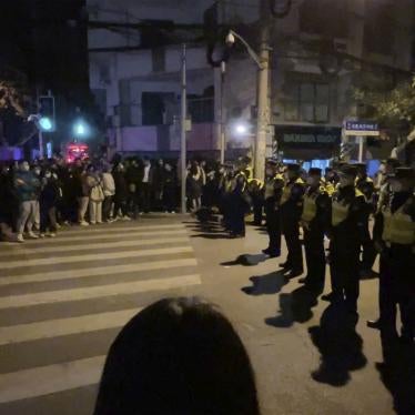 Chinese police officers block off access to a site where protesters had gathered in Shanghai on November 27, 2022.