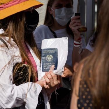 A Belarusian woman holds her passport outside the Belarusian Embassy in Warsaw, Poland, August 9, 2020. 