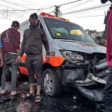 People gather around an ambulance damaged in a strike in front of Al-Shifa hospital in Gaza City on November 3, 2023. 