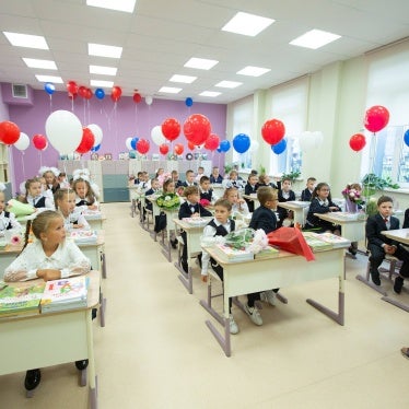 Children sit at desks in a classroom 