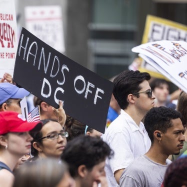 A person holds a sign that reads "Hands off DC" at a rally 