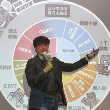 Puma Shen stands in front of a projected slide