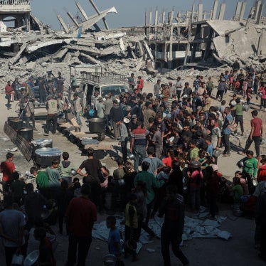 Palestinians flock to the area where a charitable organization distributes hot food as food crisis persists in Beit Lahia, Gaza on October 28, 2025. 